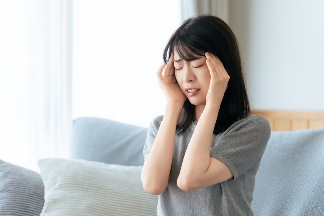騒音に悩まされて頭をかかえる女性
