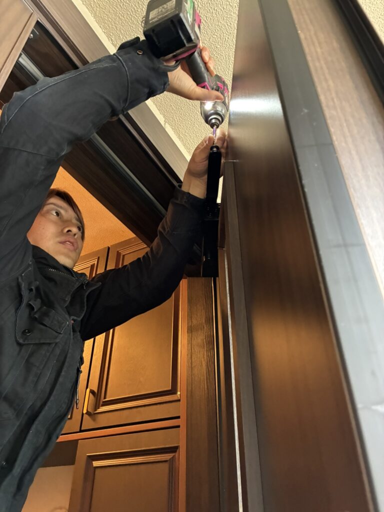 ドアクローザーのネジを打ち込む様子