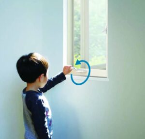 オペレーターハンドルを使ってすべり出し窓を開ける子供