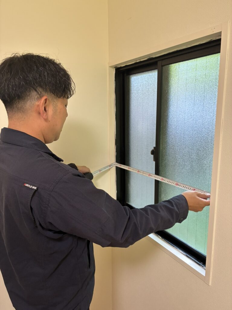 窓の寸法を測るスタッフ